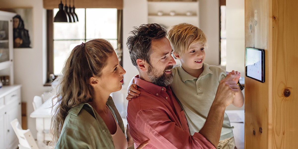 Family checking smart thermostat